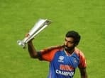 India's Jasprit Bumrah waves the World Cup trophy before a victory lap at the Wankhede stadium in Mumbai