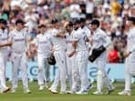 England's Mark Wood celebrates his five-wicket haul with teammates after taking the wicket of West Indies' Shamar Joseph, caught out by Harry Brook.