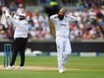 England's Moeen Ali reacts after Australia's Pat Cummins hits a six off his bowling